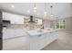 Bright modern kitchen featuring a large island, quartz countertops, and stainless steel appliances at 13751 Sw 49Th Pl, Ocala, FL 34481