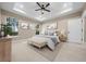 Stylishly furnished main bedroom with tray ceiling, three windows, and neutral tones, creating a serene retreat at 13751 Sw 49Th Pl, Ocala, FL 34481