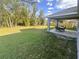 A well-manicured backyard features a covered patio with outdoor seating and mature trees at 15055 Se 93Rd Ct, Summerfield, FL 34491
