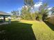 View of backyard featuring a large lawn, privacy fence, and mature trees offering shade at 15055 Se 93Rd Ct, Summerfield, FL 34491