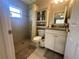 Bathroom featuring a tiled shower with a window, a vanity with a granite countertop, and tile flooring at 15055 Se 93Rd Ct, Summerfield, FL 34491
