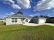 A well-maintained single-story home with gray stucco, a two-car garage, and a front yard at 15055 Se 93Rd Ct, Summerfield, FL 34491