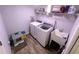 Laundry room with modern washer and dryer, utility sink, and shelving for storage at 15055 Se 93Rd Ct, Summerfield, FL 34491