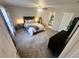 Spacious main bedroom with a ceiling fan, carpet floors, ensuite bathroom, and a large window at 15055 Se 93Rd Ct, Summerfield, FL 34491