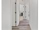 Hallway with gray laminate wood flooring, and doors leading to different rooms at 19533 Sw 86Th Ln, Dunnellon, FL 34432