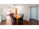 View of a dining area with hardwood floors, a wooden table, and access to a living room at 2013 Cardona Way, The Villages, FL 32159