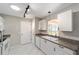 Bright kitchen features white cabinets, countertops, and stainless steel sink at 2013 Cardona Way, The Villages, FL 32159