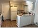 Cozy kitchen with white cabinets, white appliances and wood-look flooring at 23 Juniper Pass Ln, Ocala, FL 34480