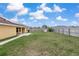 View of the backyard featuring a well-maintained lawn, wood fencing, and ample space at 234 Locust Pass Loop, Ocala, FL 34472