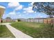 A spacious backyard with a well-maintained lawn, a brick patio and a tall wooden privacy fence at 234 Locust Pass Loop, Ocala, FL 34472