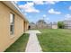 A detailed view of the backyard featuring a well-kept lawn and a walkway to the patio at 234 Locust Pass Loop, Ocala, FL 34472