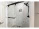 Modern bathroom with a glass shower door, dual shower head, and beautiful marble-style tiling at 234 Locust Pass Loop, Ocala, FL 34472