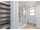 Updated bathroom with glass shower and organized closet shelving at 234 Locust Pass Loop, Ocala, FL 34472