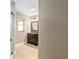 View into bathroom with brown vanity, tiled floors, and window above at 234 Locust Pass Loop, Ocala, FL 34472