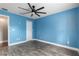 Bright blue bedroom with laminate wood flooring and ceiling fan at 234 Locust Pass Loop, Ocala, FL 34472