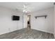 Bedroom with gray wood-look floors, ceiling fan, shelf and door to bathroom at 234 Locust Pass Loop, Ocala, FL 34472