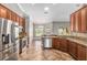 Open kitchen with stainless steel appliances, brown cabinets and dining area at 234 Locust Pass Loop, Ocala, FL 34472