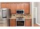 Kitchen featuring stainless appliances, granite counters, tile backsplash and wooden cabinets at 234 Locust Pass Loop, Ocala, FL 34472