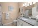 Bathroom featuring granite countertop, white cabinets, a tiled shower, and decorative accents at 3060 Ne 35Th St, Ocala, FL 34479