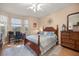 Comfortable bedroom with a wooden bed frame, a desk with an office chair, and a ceiling fan at 3060 Ne 35Th St, Ocala, FL 34479