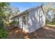 Side view of a white home with well-manicured landscaping and many windows at 3060 Ne 35Th St, Ocala, FL 34479