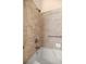 Close-up of a bathtub featuring tile walls, a shower head, grab bars, and soap holder at 3060 Ne 35Th St, Ocala, FL 34479