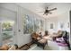 Bright sunroom featuring a ceiling fan, large windows, comfortable seating, and neutral tones offering a relaxing space at 3060 Ne 35Th St, Ocala, FL 34479