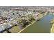 Wide aerial view showcasing a residential neighborhood near a lake and lush greenery at 3321 Woodridge Dr, The Villages, FL 32162
