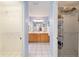 Dual-entry bathroom with white tile floors, a dual vanity, and separate walk-in closets at 3321 Woodridge Dr, The Villages, FL 32162