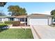 Charming single-story home featuring a well-manicured lawn, mature shrubs, and an attached two-car garage at 3321 Woodridge Dr, The Villages, FL 32162