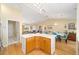 Eat-in kitchen with white countertops, wood cabinets, and an open floor plan to the living and dining areas at 3321 Woodridge Dr, The Villages, FL 32162