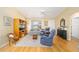Inviting living room with hardwood floors, blue furnishings, built-in shelving, and natural light from the front windows at 3321 Woodridge Dr, The Villages, FL 32162