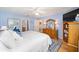 Comfortable primary bedroom with wood floors, blue accents, and a full dresser with a mirror and bedside lamps at 3321 Woodridge Dr, The Villages, FL 32162