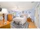 Comfortable primary bedroom features blue accents, a ceiling fan, wood floors, a bench, and two bedside tables at 3321 Woodridge Dr, The Villages, FL 32162