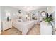Bright main bedroom with a large window, decorative mirrors and a comfortable bed with stylish linens and décor at 3321 Woodridge Dr, The Villages, FL 32162