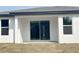 Exterior view of the home's back, featuring windows and sliding glass doors to patio at 3628 Sw 133Rd Loop, Ocala, FL 34473