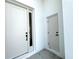 Bright white front door with black hardware and narrow sidelight window at 3628 Sw 133Rd Loop, Ocala, FL 34473
