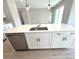 Kitchen island featuring stainless steel dishwasher, white cabinets, and an undermounted stainless steel sink at 3628 Sw 133Rd Loop, Ocala, FL 34473