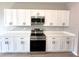 Modern kitchen boasts white cabinets, sleek hardware, stainless steel appliances, and durable countertops at 3628 Sw 133Rd Loop, Ocala, FL 34473