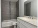 Bathroom featuring a shower-tub combo with sleek gray tile and a decorative tile accent at 3894 Se 143Rd Pl, Summerfield, FL 34491