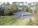 A gray home with a flat backyard and sliding glass doors to a small concrete porch at 3896 Sw 177Th Ter, Dunnellon, FL 34432