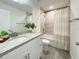 Well-lit bathroom featuring a granite countertop, a mirror, a shower with gray tiles and a decorative shower curtain at 3896 Sw 177Th Ter, Dunnellon, FL 34432