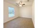 Bedroom with neutral carpet, a ceiling fan, and a large window overlooking a lush backyard at 3896 Sw 177Th Ter, Dunnellon, FL 34432