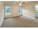 A clean bedroom with carpet, ceiling fan, and good lighting, and two windows with outside views at 3896 Sw 177Th Ter, Dunnellon, FL 34432