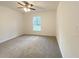 Cozy bedroom featuring plush carpeting, a ceiling fan and a window with a view of the outdoors at 3896 Sw 177Th Ter, Dunnellon, FL 34432