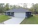 Charming single-story home featuring a spacious two-car garage, gray stucco, and meticulously maintained lawn at 3896 Sw 177Th Ter, Dunnellon, FL 34432