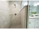 Modern walk-in shower featuring neutral tile and a glass partition to the bathroom at 3896 Sw 177Th Ter, Dunnellon, FL 34432