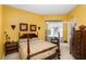 Comfortable bedroom with yellow walls, a traditional bed, and patio access at 5891 Nw 26Th St, Ocala, FL 34482