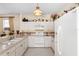 Charming kitchen with white appliances and cabinets, accented with decorative items on top of cabinets at 5891 Nw 26Th St, Ocala, FL 34482
