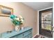Bright entryway featuring a decorative blue dresser, attractive mirror, and beautiful floral arrangement near the front door at 615 Midway Dr # B, Ocala, FL 34472